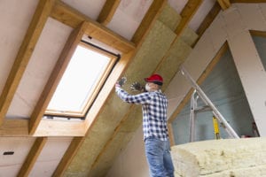 Man installing insulation in the attic